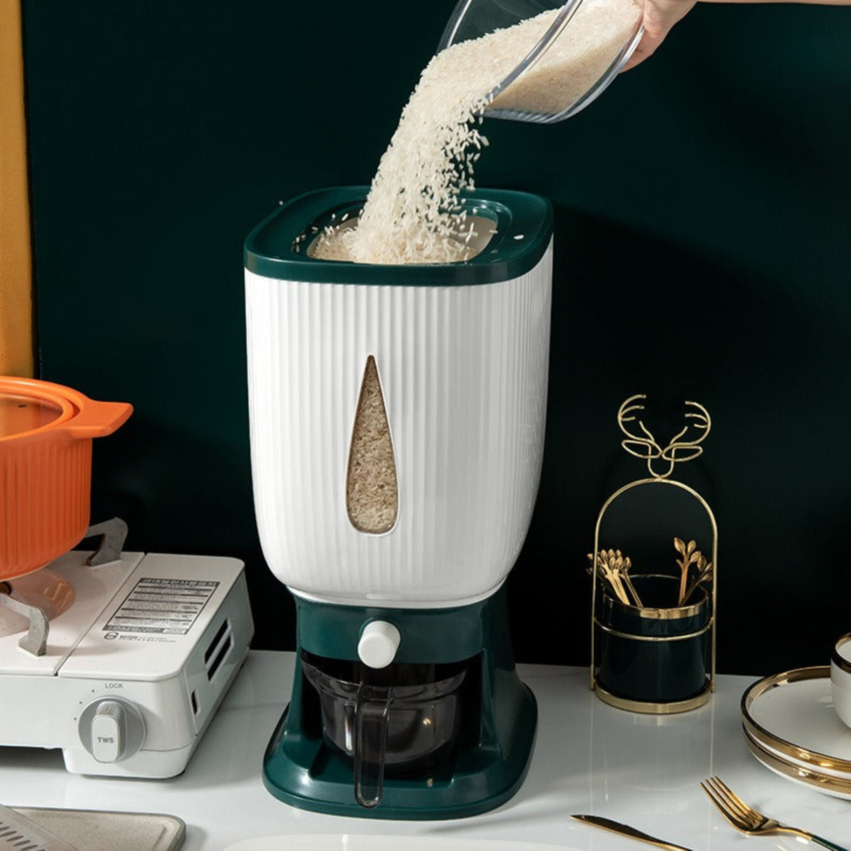 White and green grain mill on a kitchen counter with rice being poured into it.