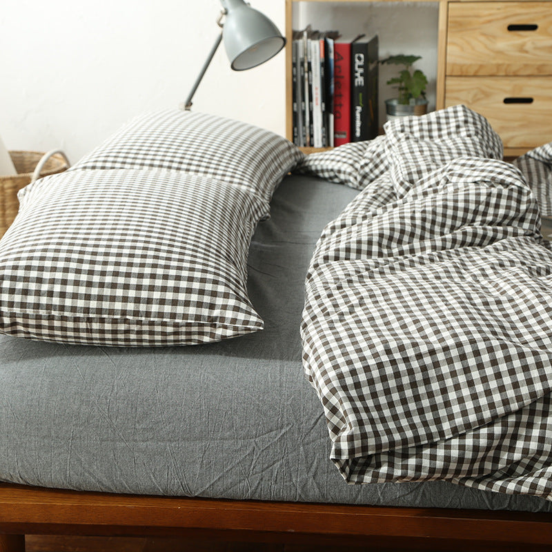 Bed with checkered bedding and pillows in a bedroom setting.