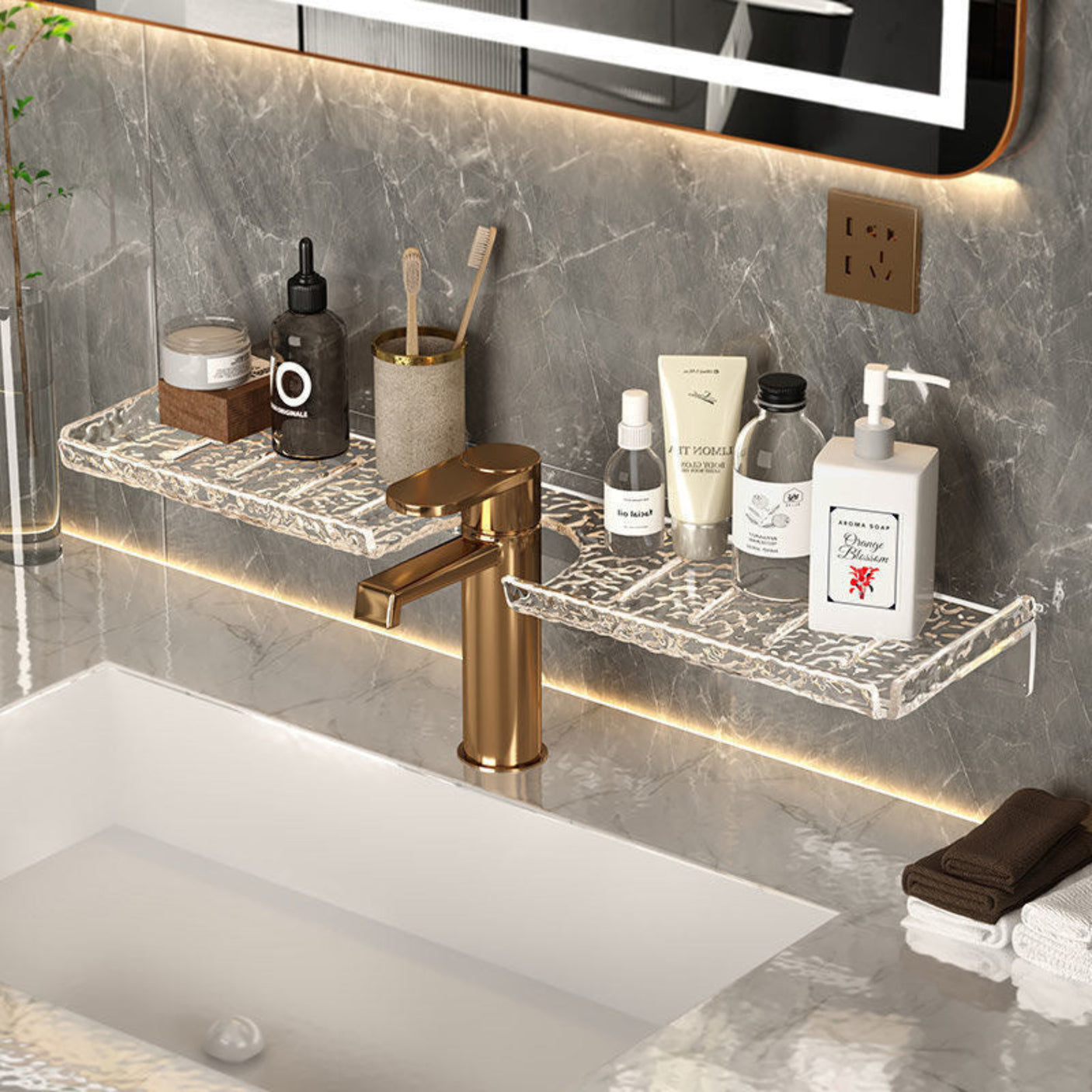 Bathroom vanity with marble shelf, faucet, and toiletries against a gray marble wall.