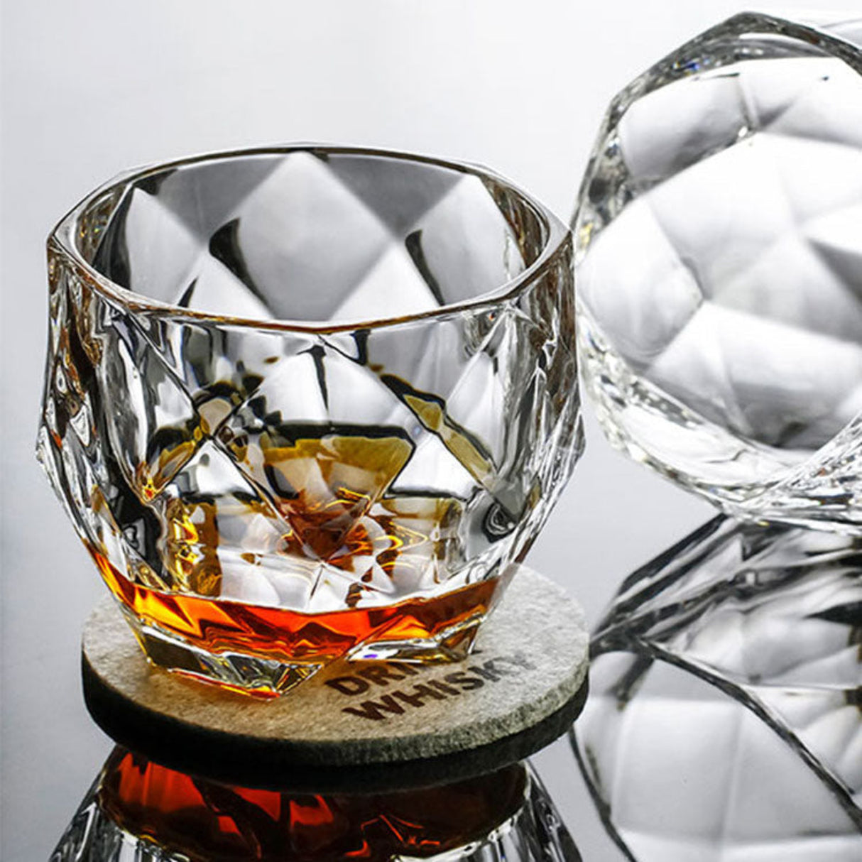 Crystal glass with whiskey on a marble coaster, blurred background