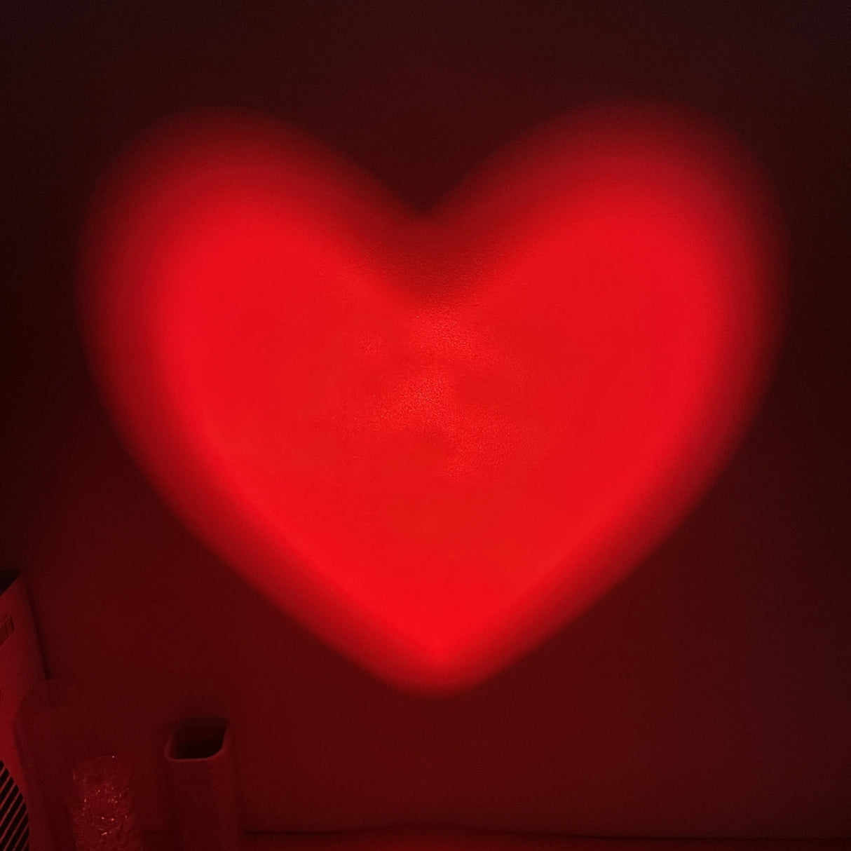 Red heart-shaped light on a dark background