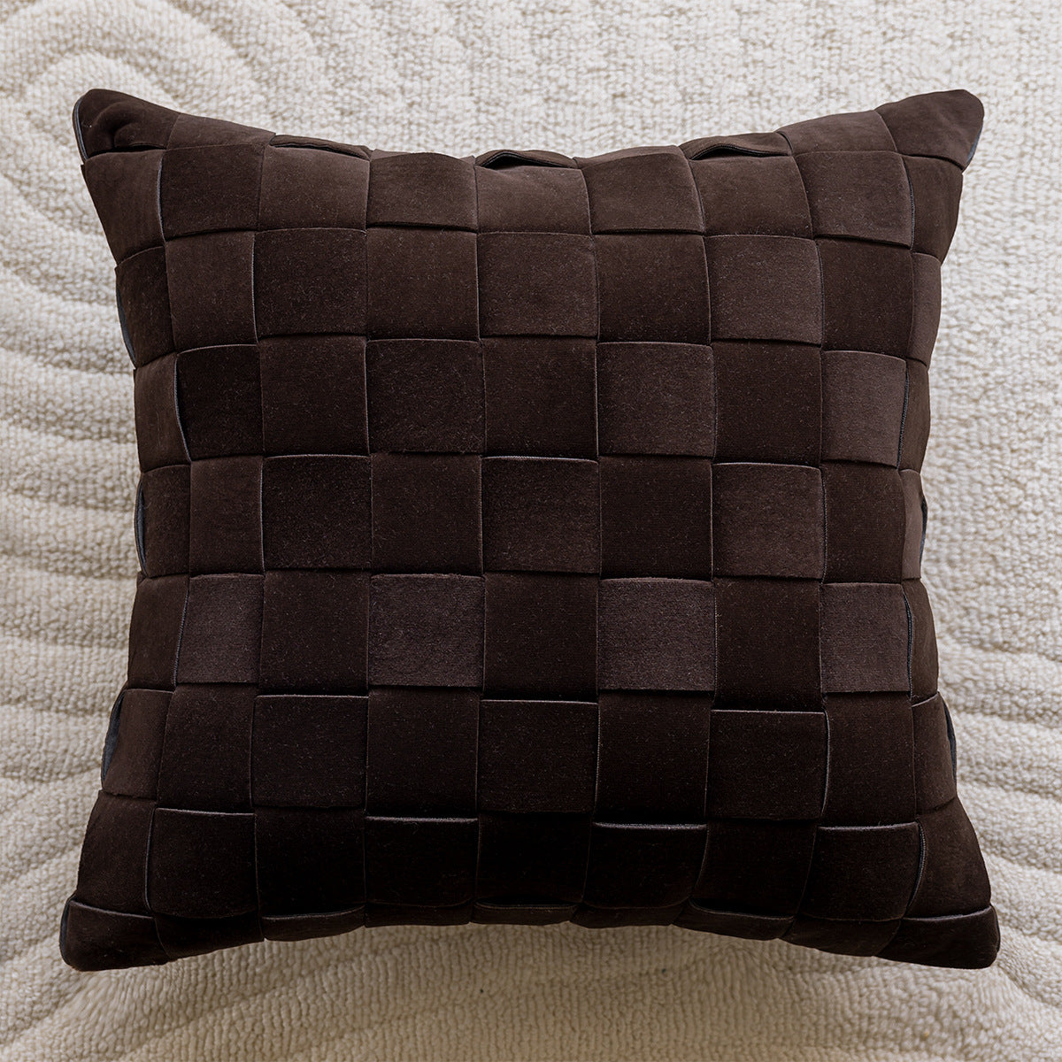Brown woven pillow on a textured beige background
