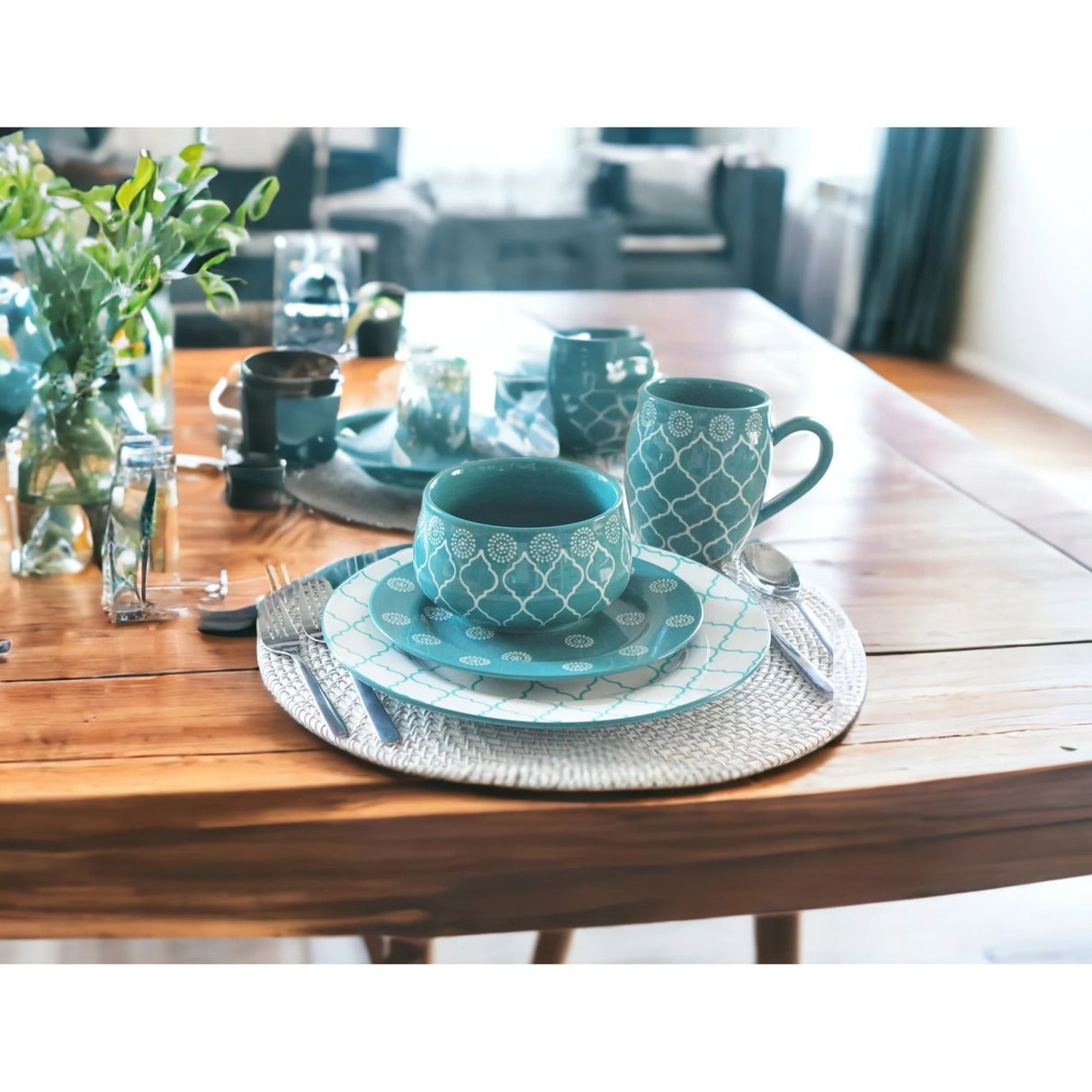Teal ceramic tableware set on a wooden table with a blurred indoor background