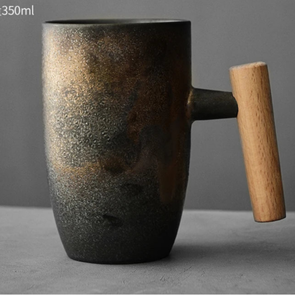 Black ceramic mug with a wooden handle on a gray background