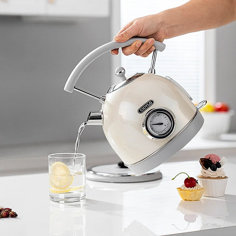 White kettle with a clock on a kitchen counter, pouring water into a glass.