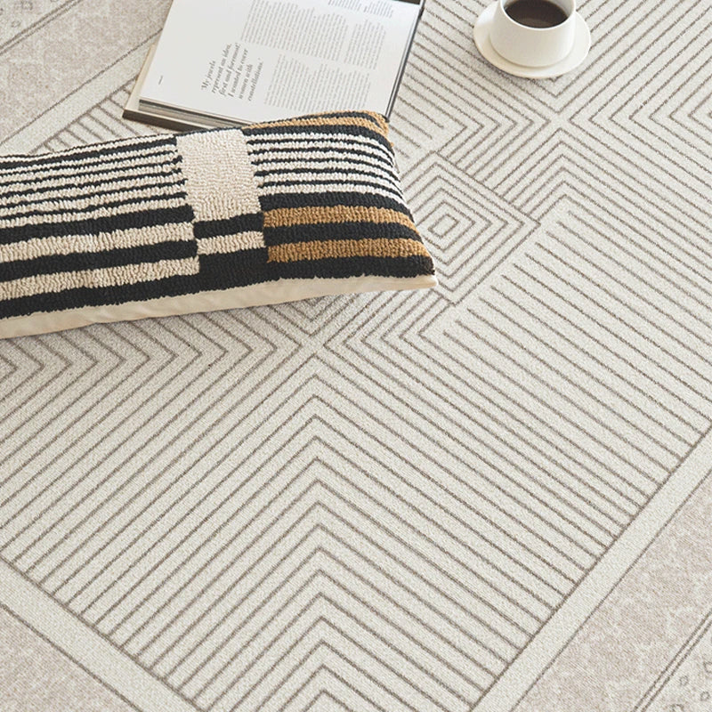 Geometric patterned rug on a floor with a book and coffee cup.