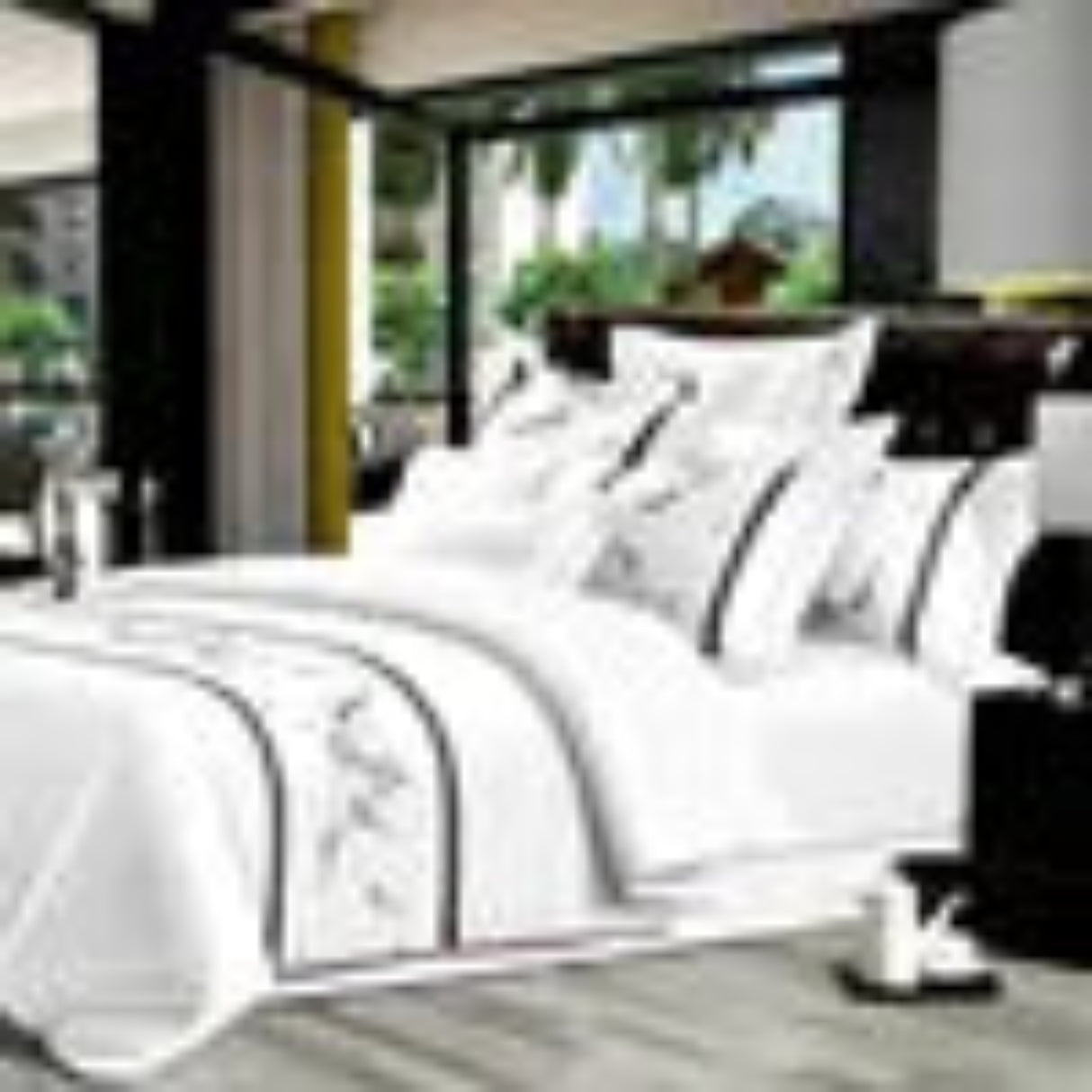 White bedding set with decorative pillows on a bed in a bedroom setting.