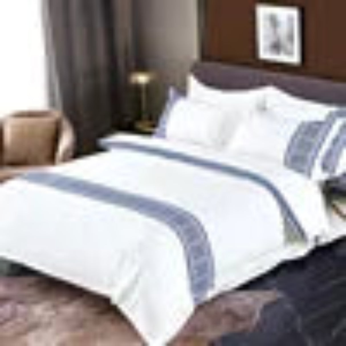 Bedding set with white duvet, blue comforter, and decorative pillows on a bed.