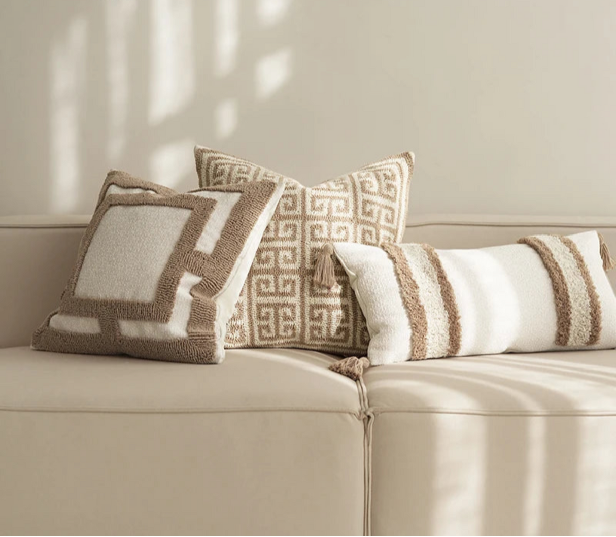 Decorative pillows on a beige sofa with 'BACKTO HOME' branding.