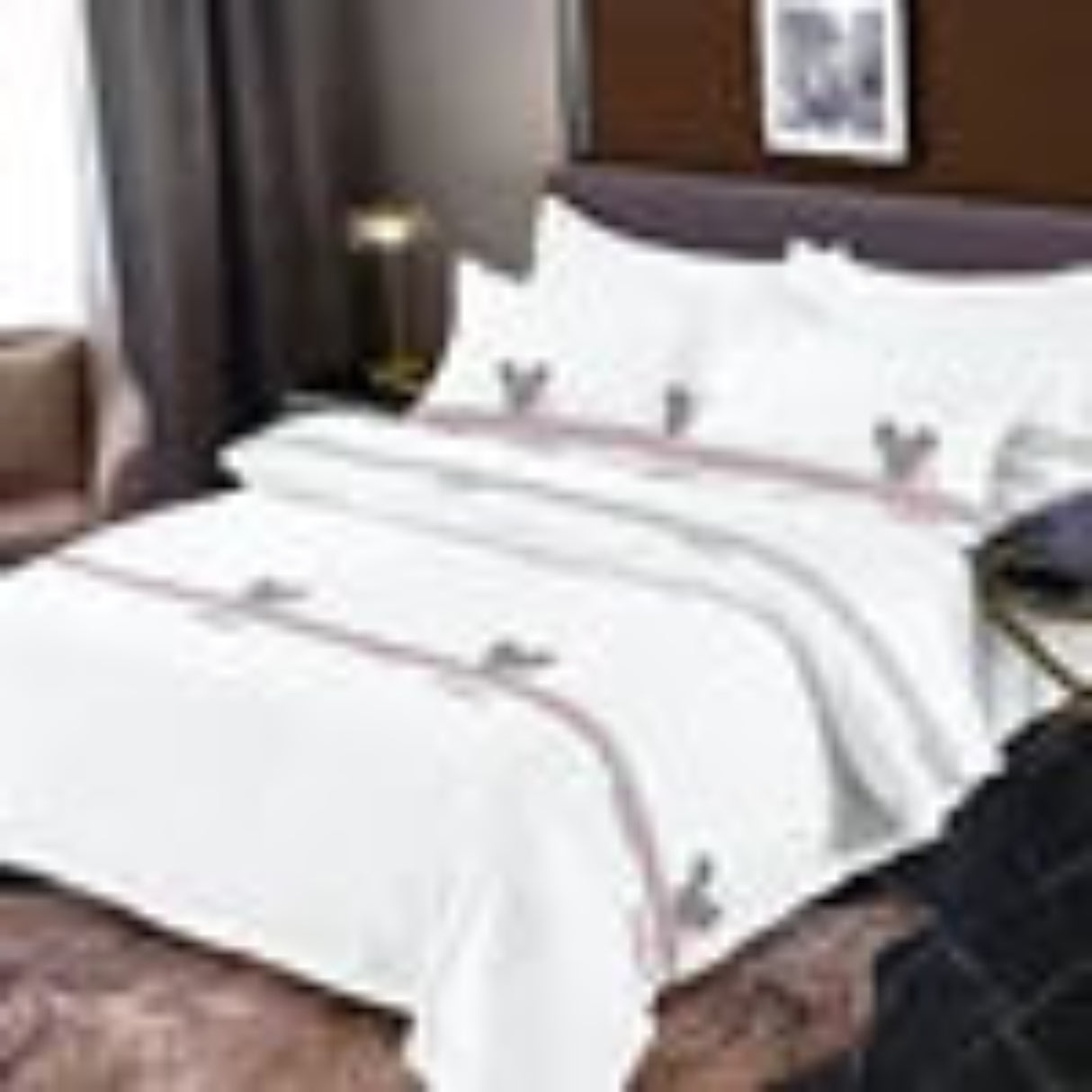 White bedding set on a bed with pillows and a comforter.