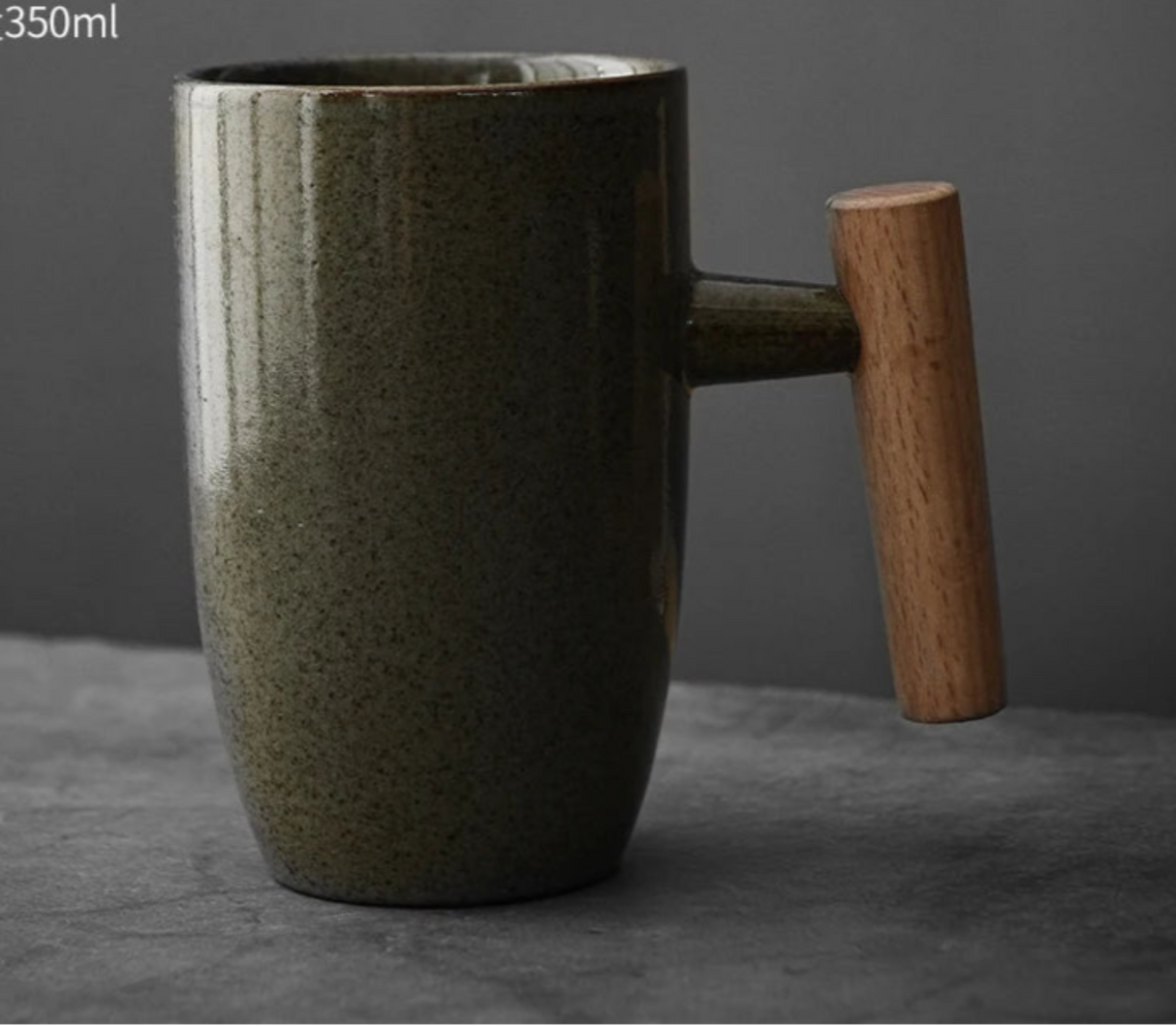 Green ceramic mug with wooden handle on a dark gray background