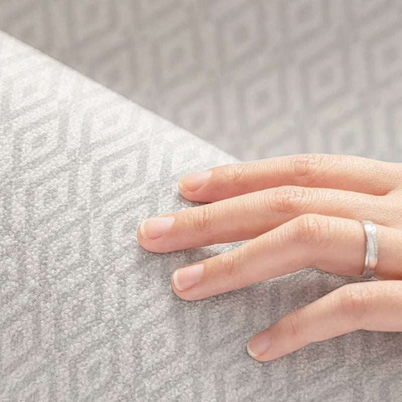 Hand wearing a ring on a textured gray surface