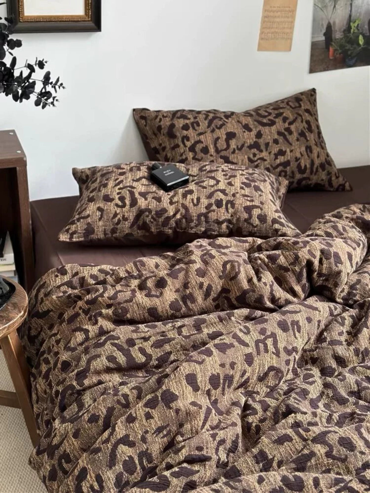 Bed with leopard print bedding and pillows in a room setting.