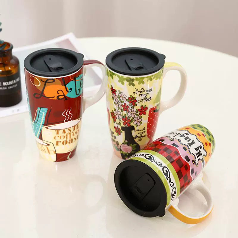 Three colorful travel mugs with various designs on a white surface.