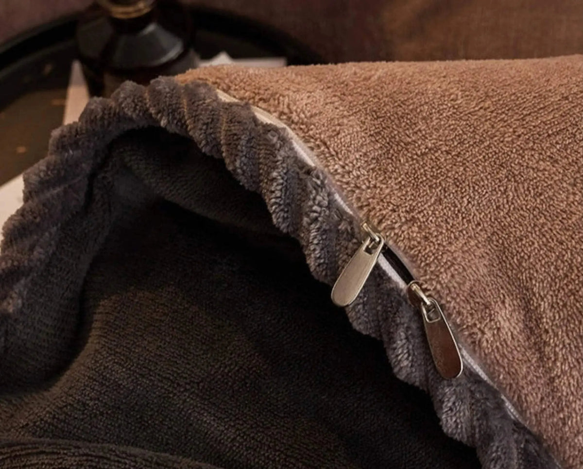 Close-up of a brown and gray fleece blanket with a zipper.