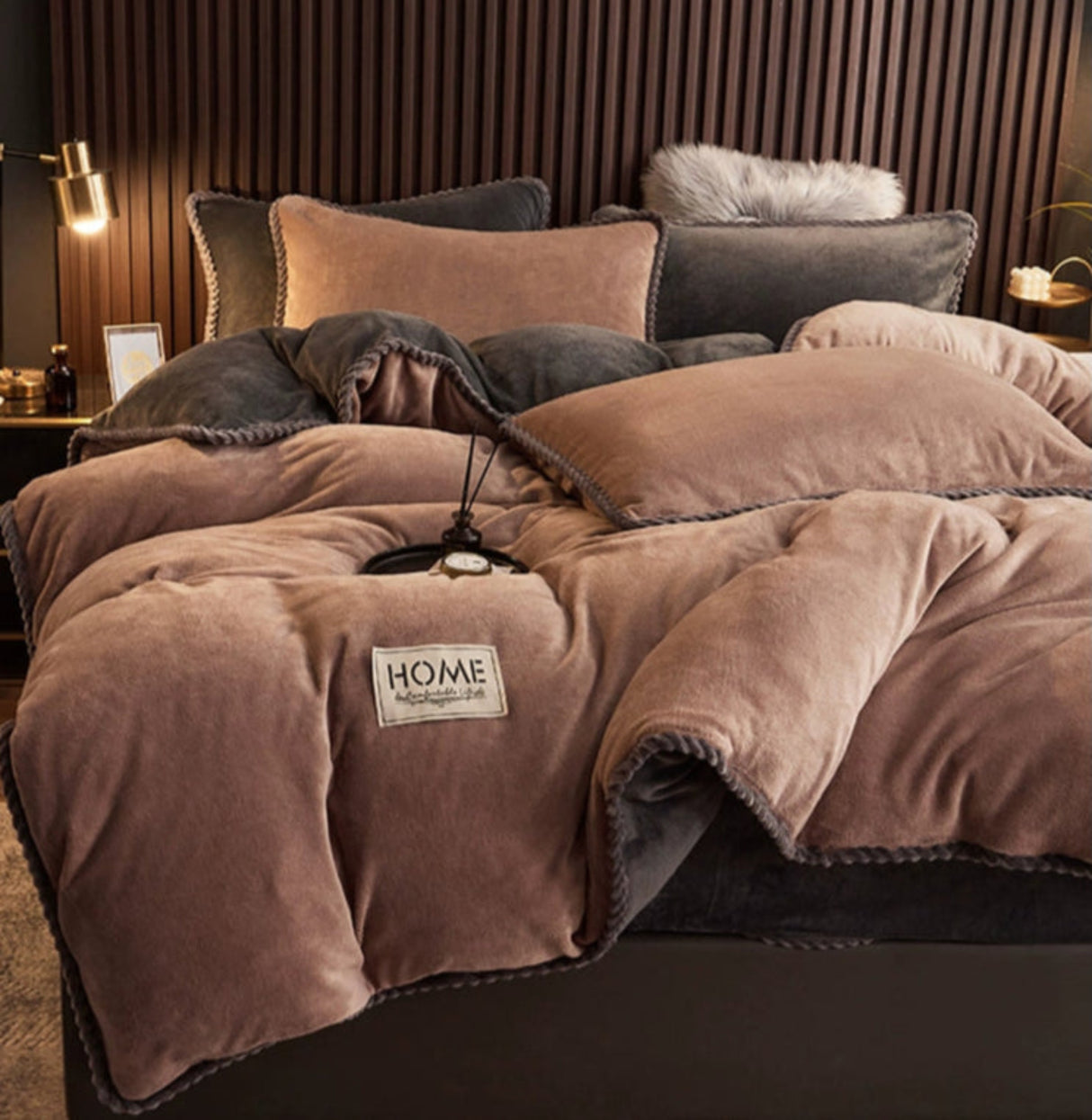Brown textured comforter with 'HOME' label on a bed in a cozy room.