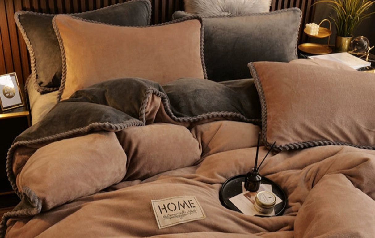 Brown textured blanket and pillows on a bed with a 'Home' sign in the foreground.