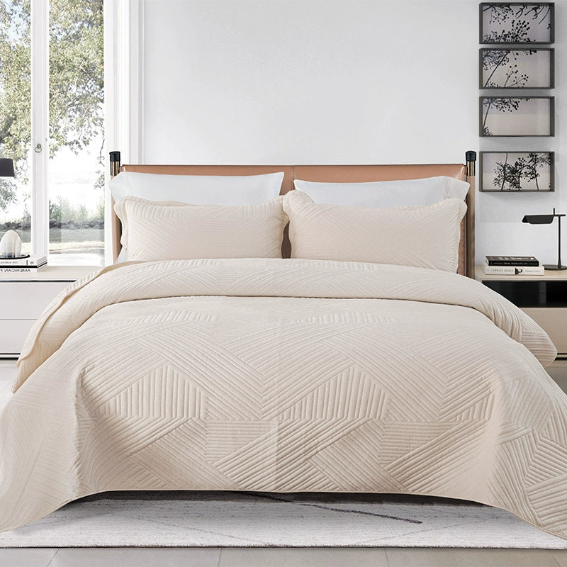 Beige quilted cover on a bed in a bedroom setting with decor elements.