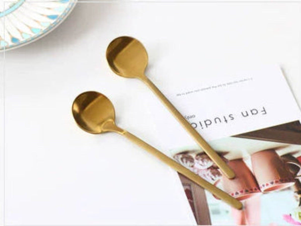 Two gold spoons on a magazine with a blurred background