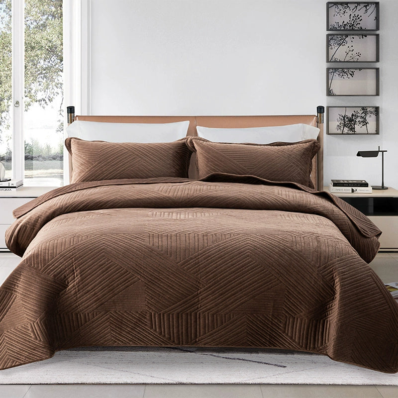 Brown quilted comforter set on a bed in a well-lit bedroom.