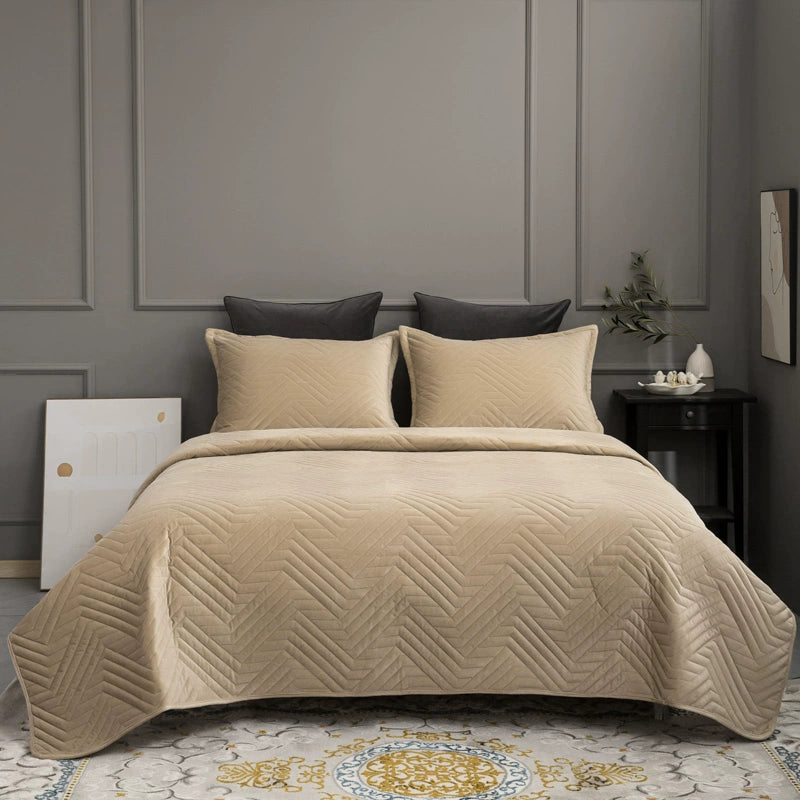 Beige quilt with geometric pattern on a bed in a bedroom setting.