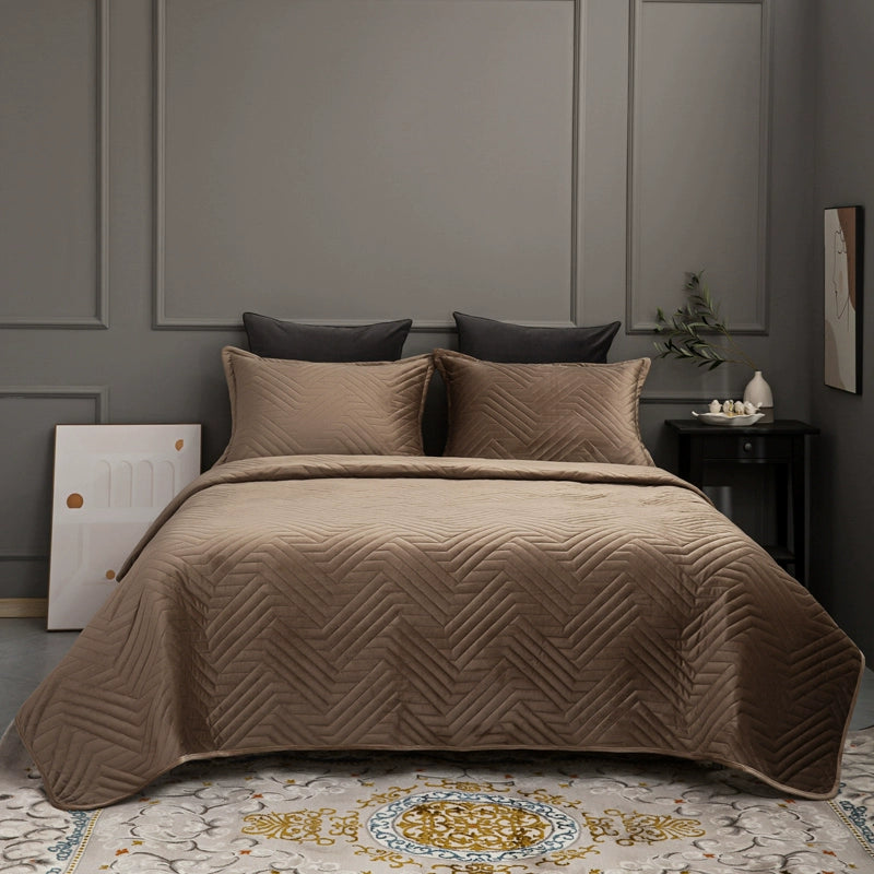 Brown quilted bedspread on a bed with matching pillows in a bedroom setting.