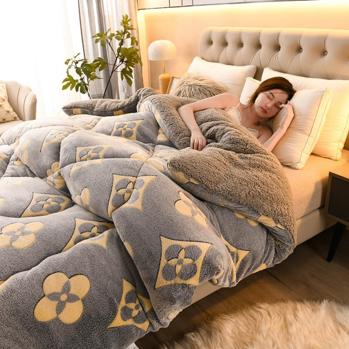 Woman lying on a bed with a floral patterned comforter in a cozy bedroom.