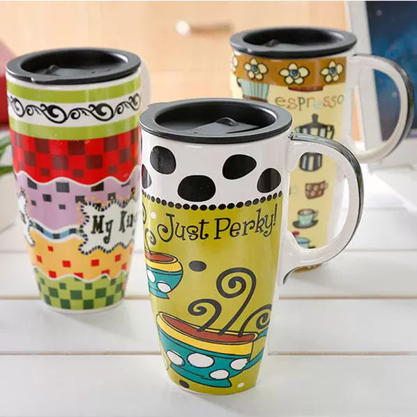 Colorful travel mugs with various designs on a light surface