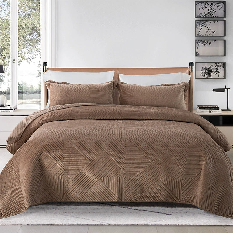 Brown quilt set on a bed in a bedroom with decor elements.