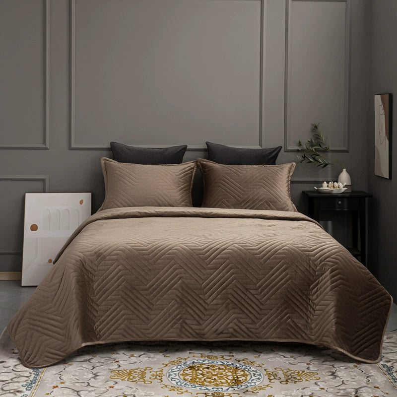 Brown quilted coverlet on a bed in a bedroom with gray walls and decorative elements.