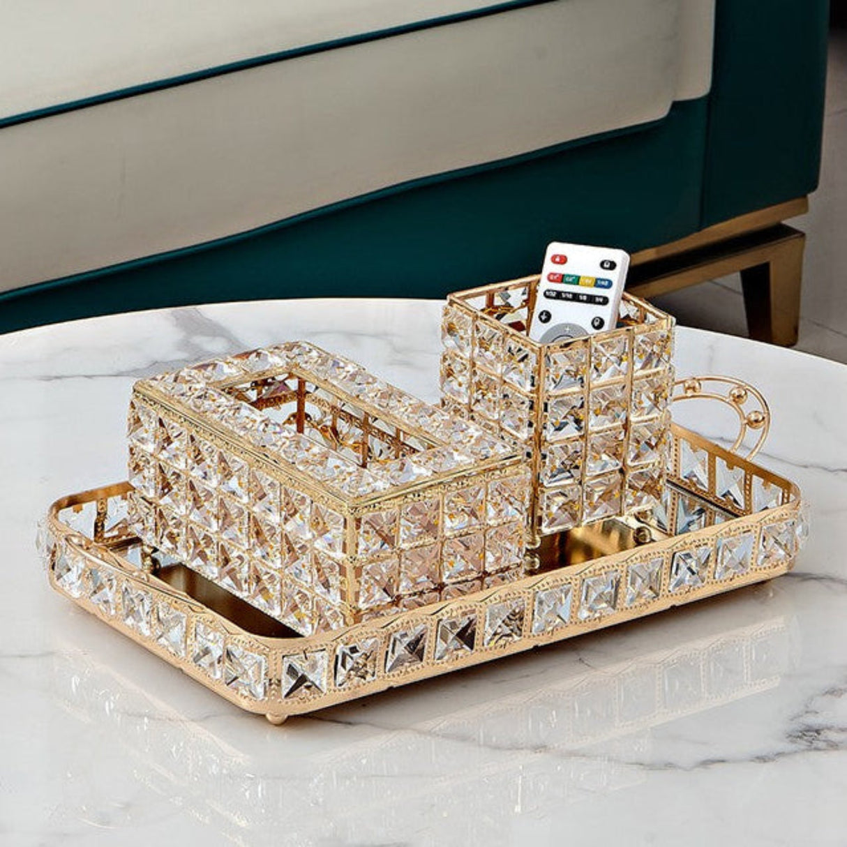Decorative crystal tray with a cup and remote control on a marble surface.