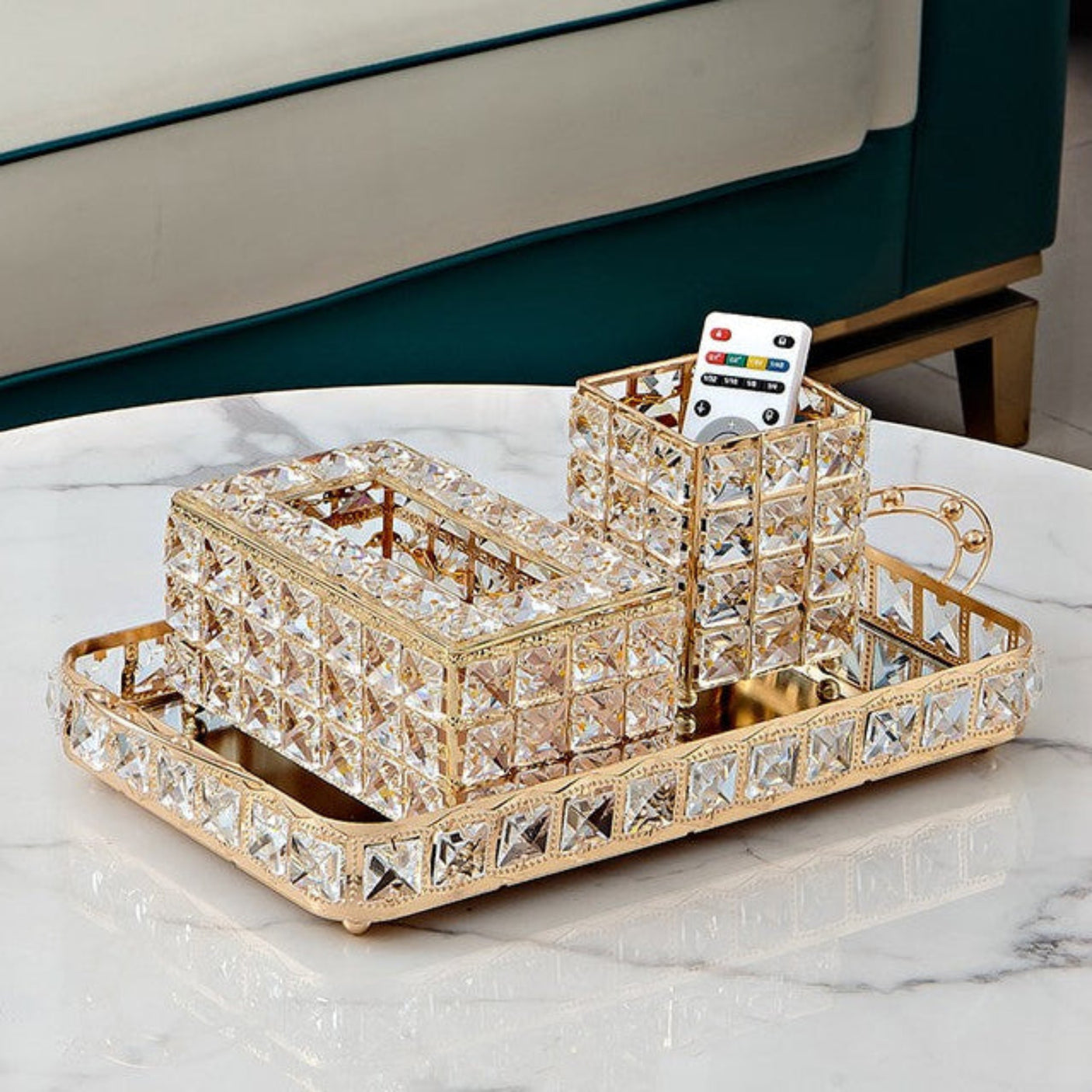Decorative crystal tray with a cup and remote control on a marble surface.