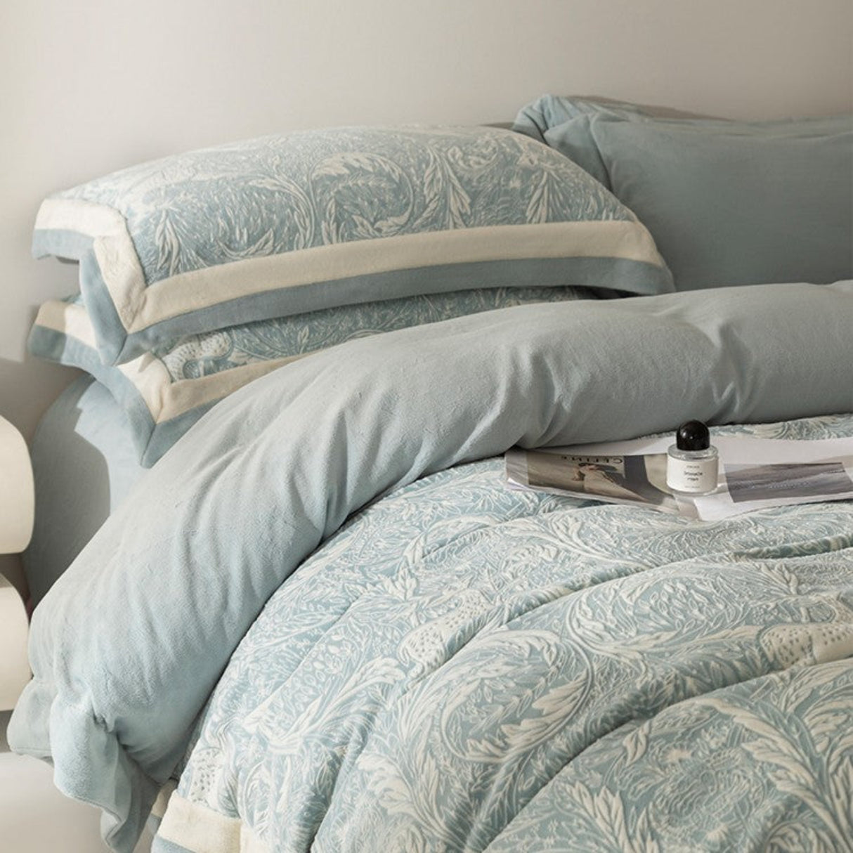 Light blue floral patterned bedding set on a bed with a neutral background.