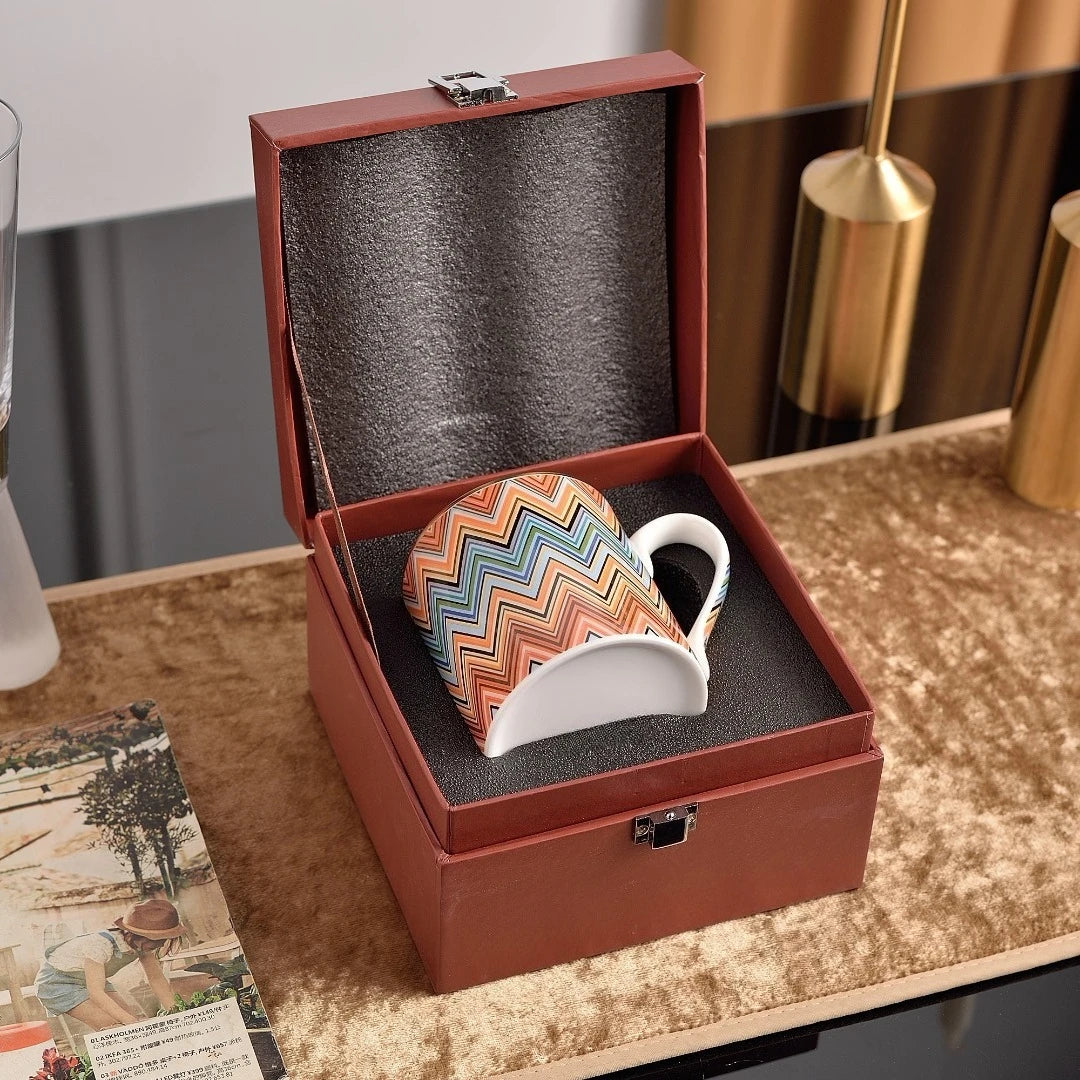 Colorful mug in a brown leather box on a wooden surface