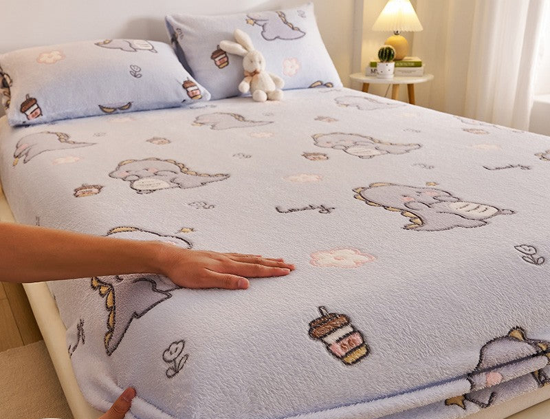 Bedding set with cartoon designs on a bed, featuring a hand touching the fabric.