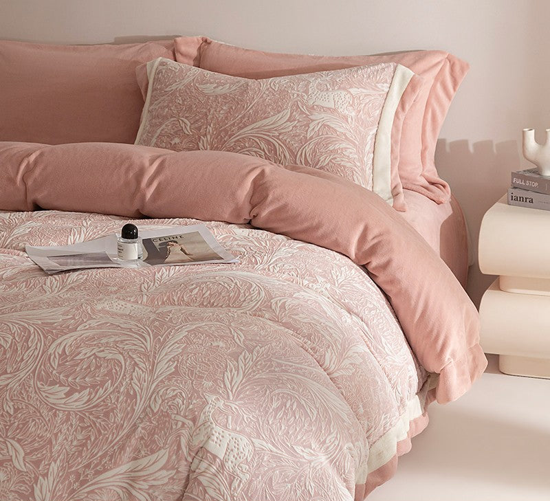 Pink floral bedding set on a bed with a nightstand in the background.
