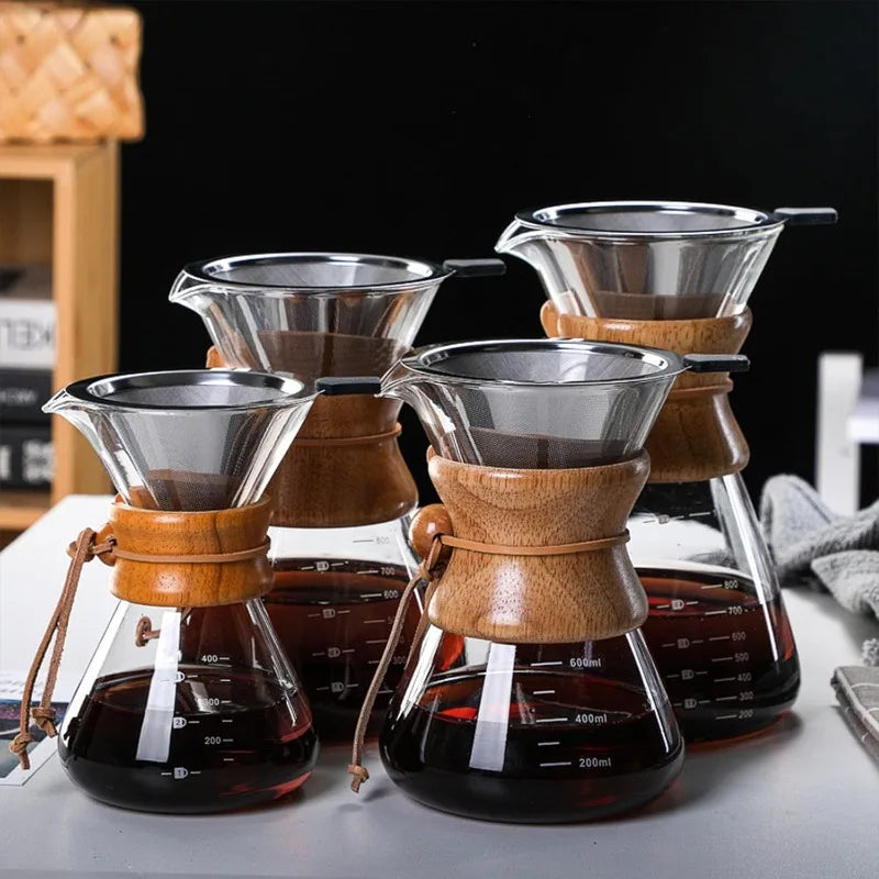 Set of four wooden coffee filters with glass carafes on a dark background