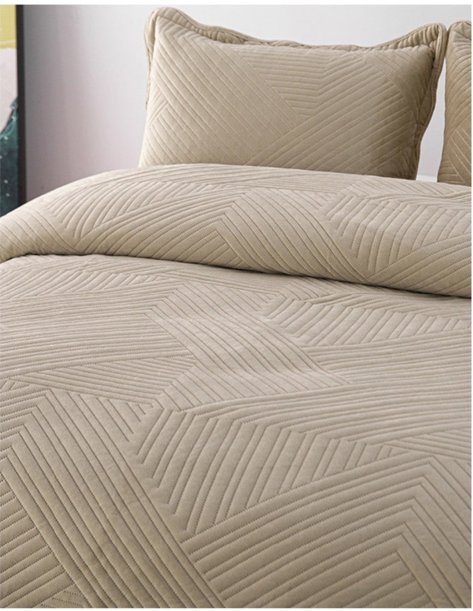 Textured bedding set with pillows on a bed, featuring geometric pattern and neutral color.