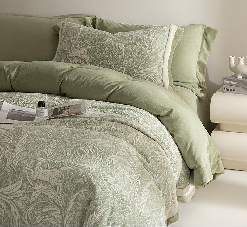 Green patterned bedding set on a bed with a nightstand in the background.