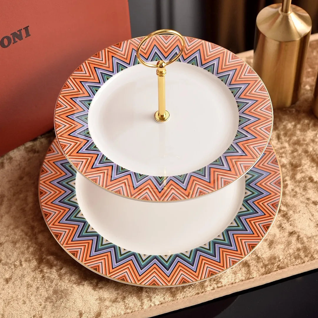 Two-tiered cake stand with colorful zigzag pattern on a textured surface