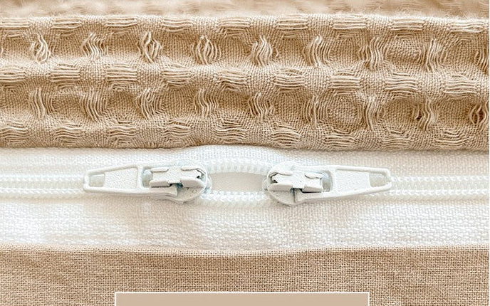 Close-up of a beige fabric with a zipper and text overlay on a white background