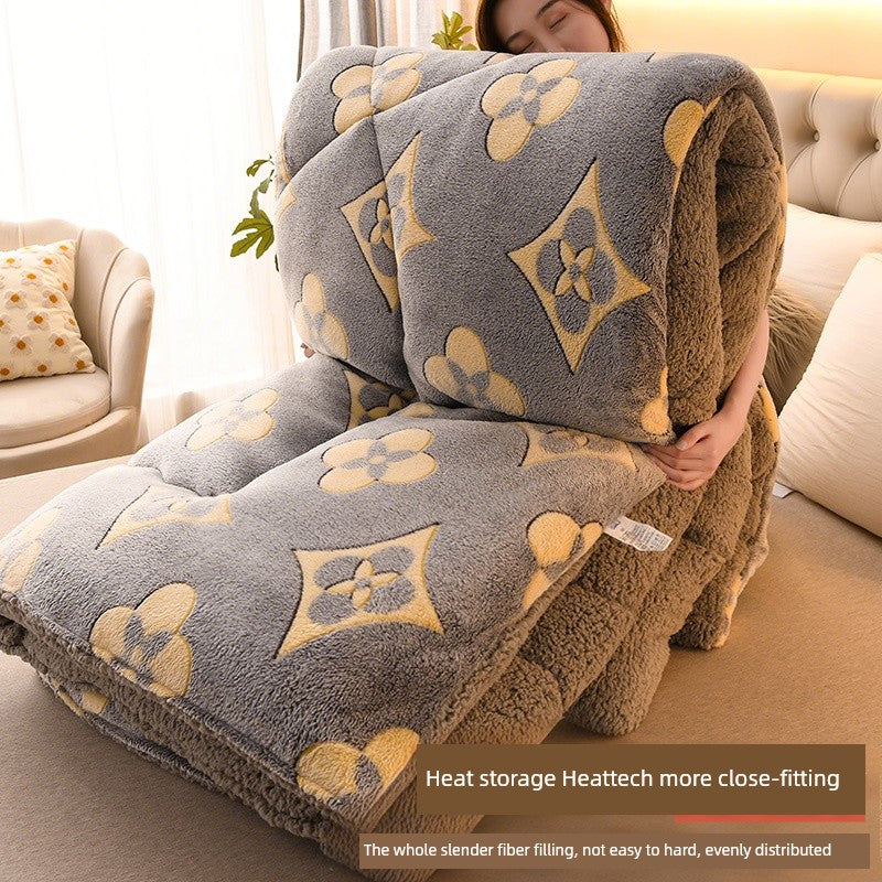 Person holding a large gray and brown patterned blanket in a living room.