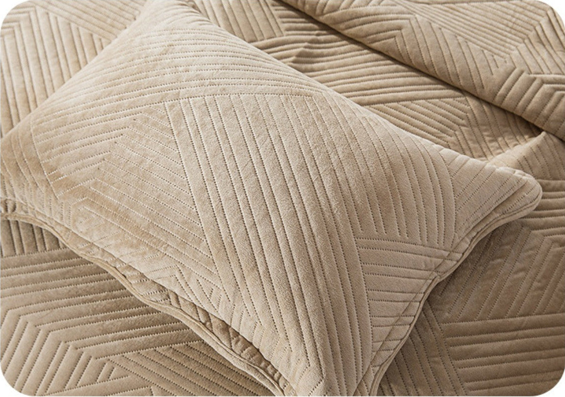 Beige textured bed cover with pillow on a white background