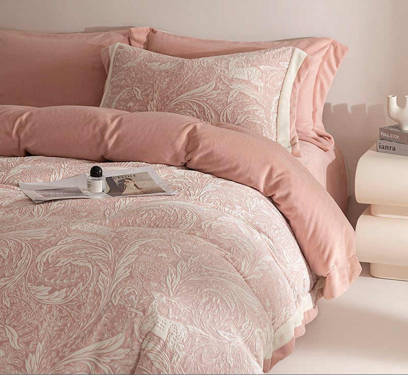 Pink floral bedding set on a bed with a nightstand in the background.
