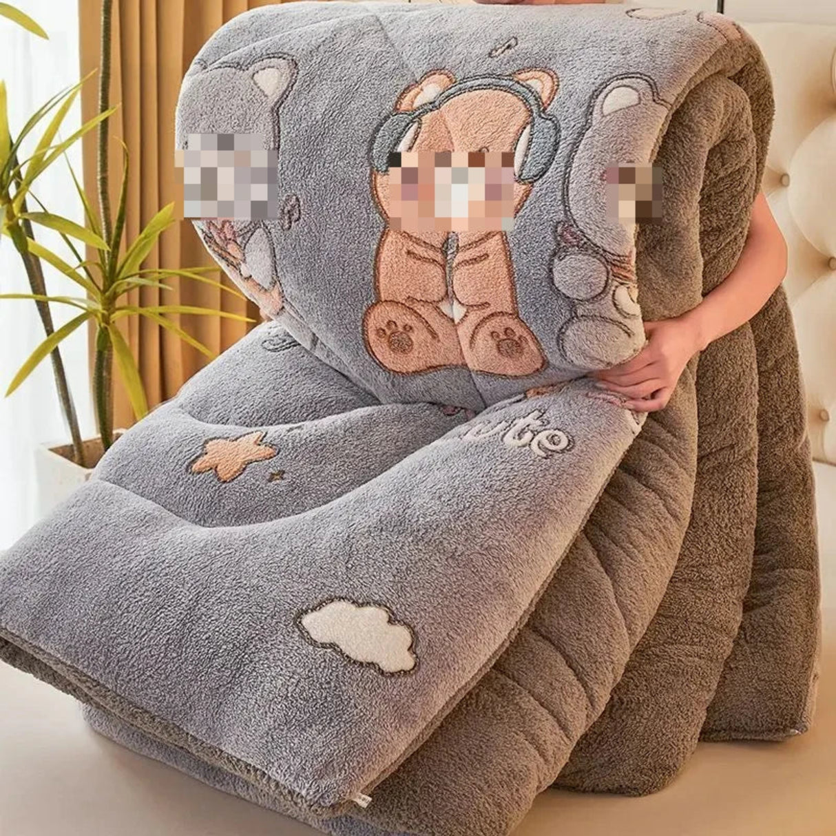 Fluffy blanket with cartoon bear design held by a person in a home setting.
