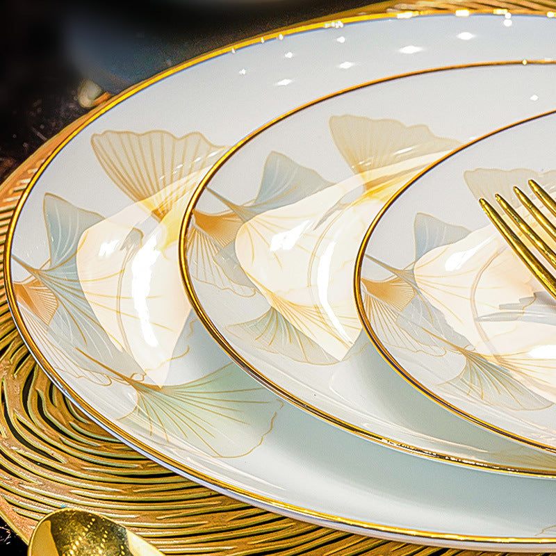 Set of ceramic plates with gold and white floral design on a dark surface