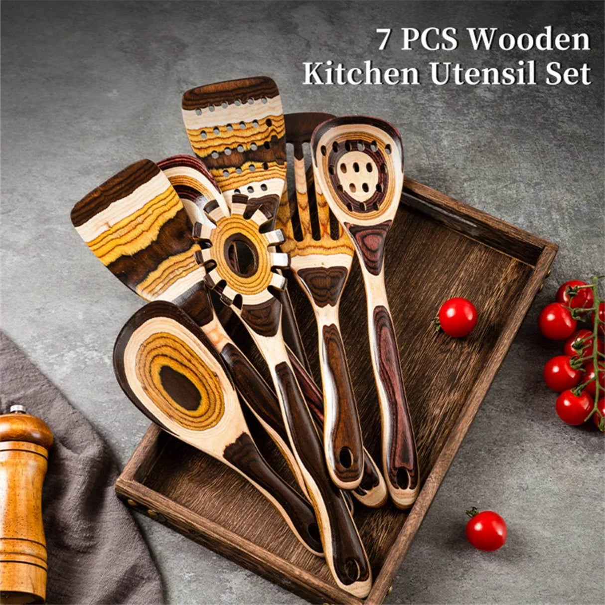 7-piece wooden kitchen utensil set on a tray with tomatoes and a towel in the background.