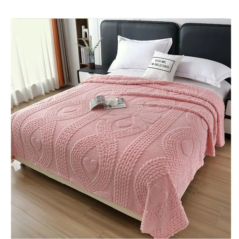 Pink blanket on a bed with white pillows in a bedroom setting