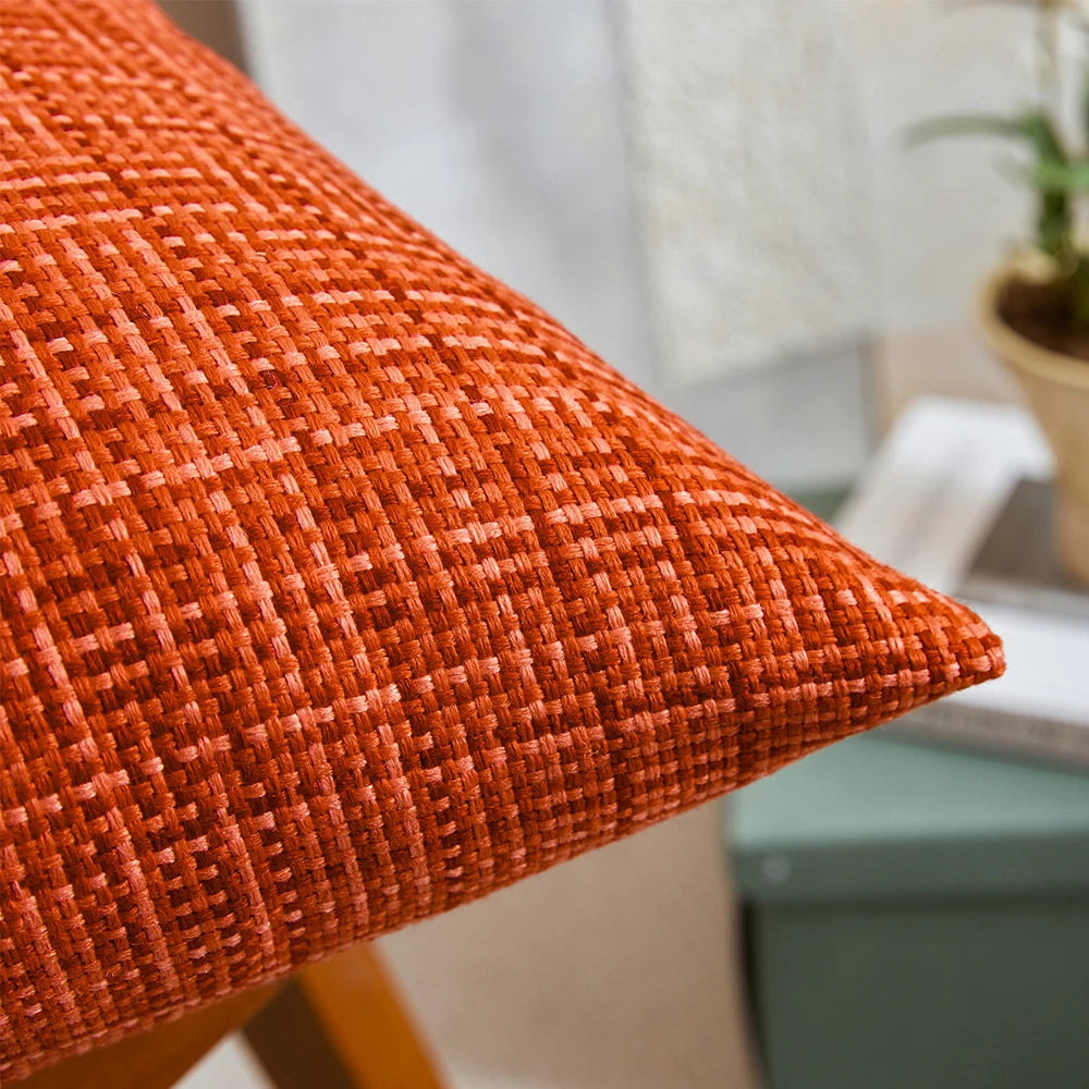 Close-up of an orange textured pillow with a blurred indoor background