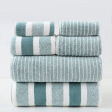 Stack of striped towels in teal and white on a light gray background